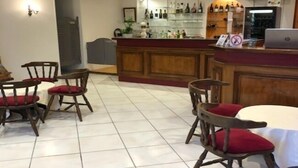 Een bar met houten stoelen en een laptop op de toonbank.