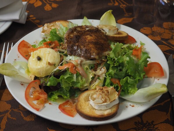 Un plato de comida con diversos vegetales y un trozo de carne a la parrilla.