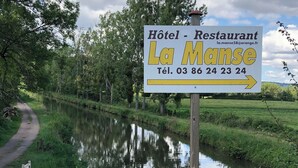 Señal para 'Hôtel - Restaurant La Mance' con un número de contacto.