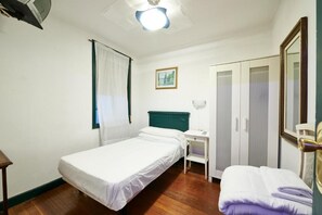 A single-bed room with a desk, wardrobe, and a painting on the wall. - Pension Areeta (Getxo)