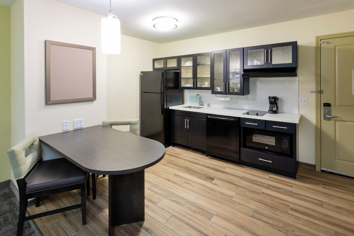 A modern kitchen with a dining table, chairs, and a built-in oven.