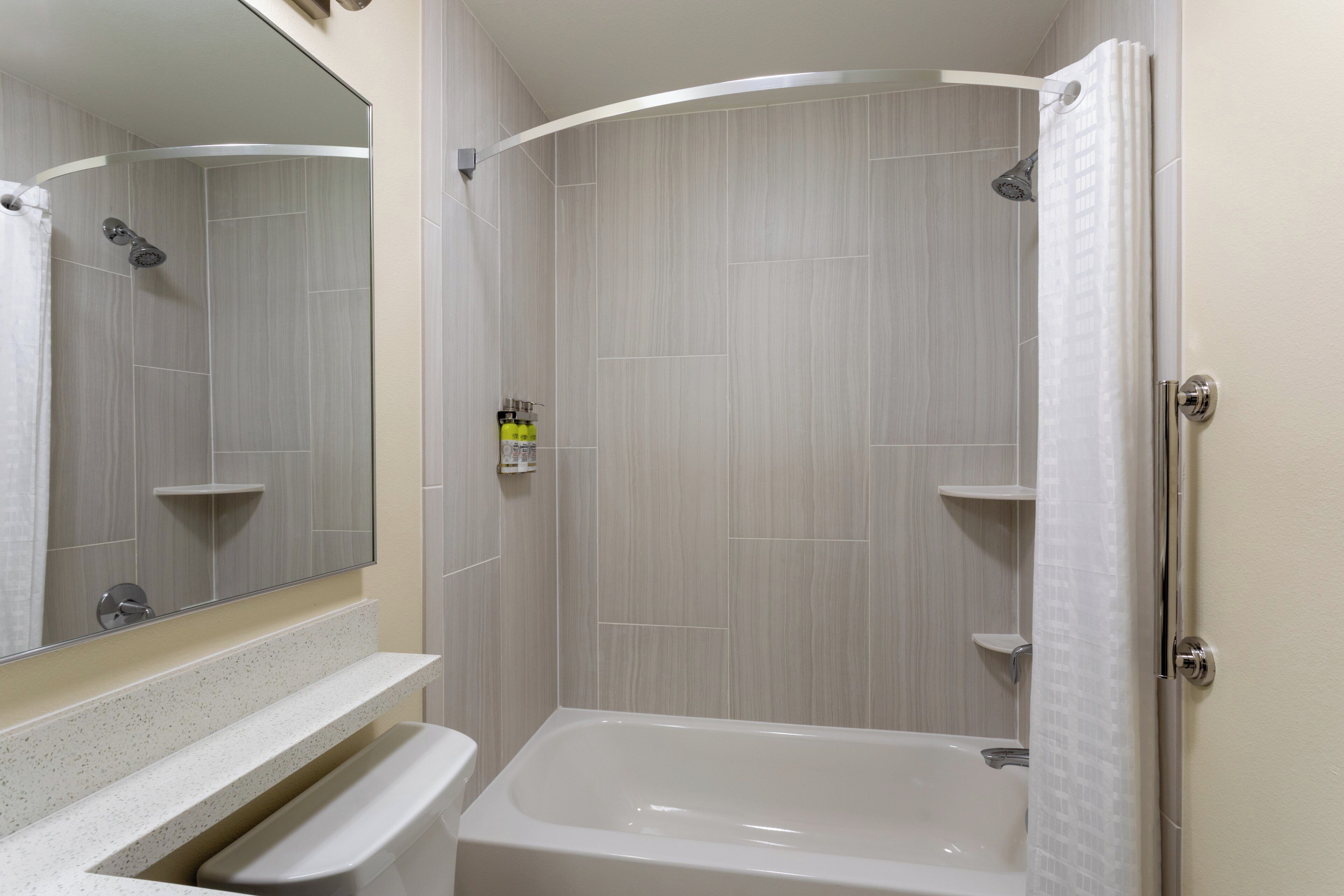 A modern bathroom with a bathtub, a shower, and a toilet.