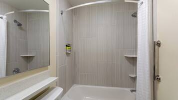 A modern bathroom with a bathtub, a shower, and a toilet.
