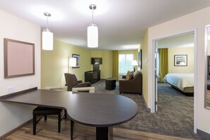 A hotel room with a dining area, a sofa, a TV, and a bed. - Candlewood Suites Rochester Mayo Clinic Area by IHG (Rochester)