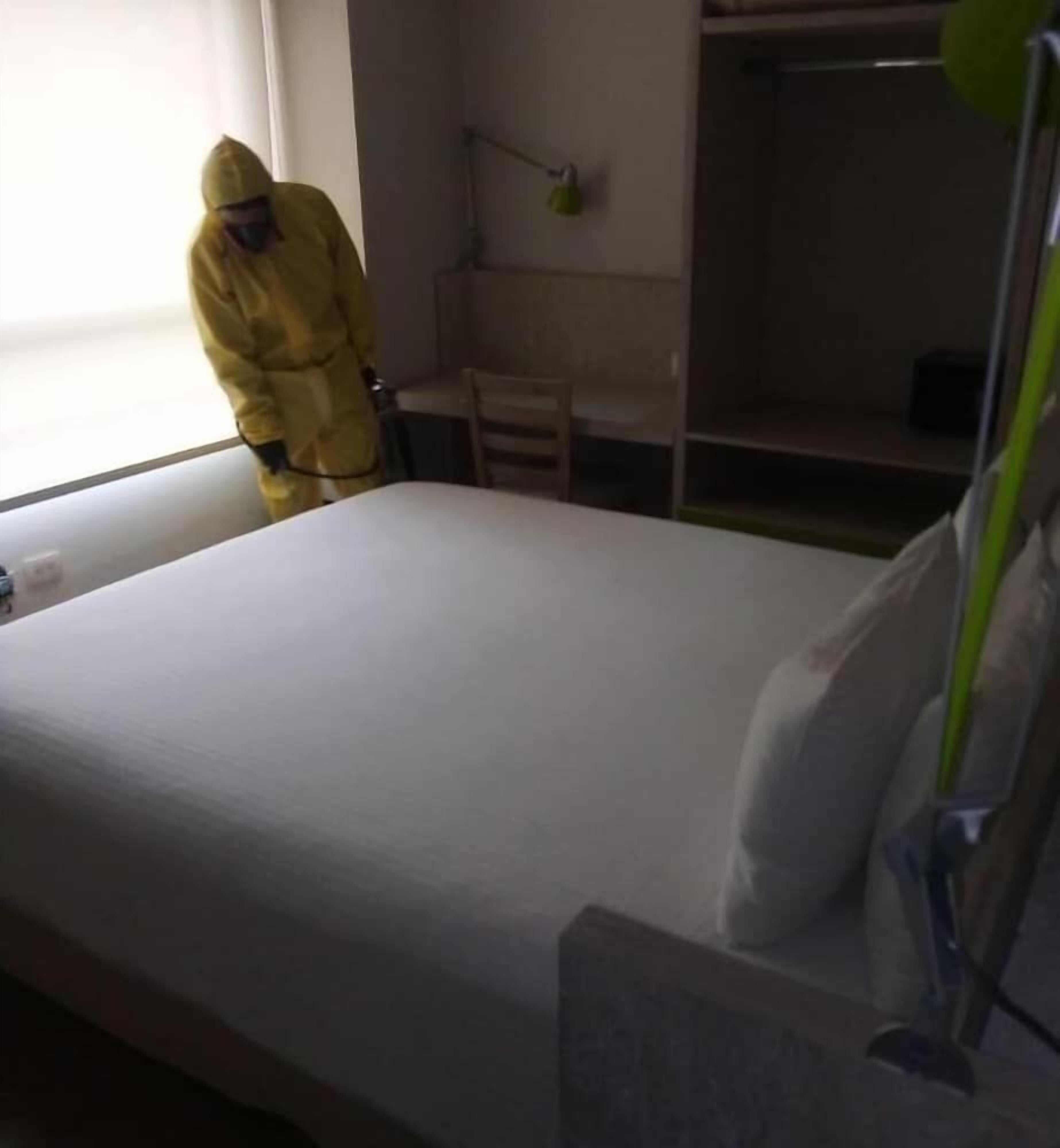 Een kamer met een bed, nachtkastje en een raam.