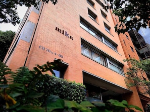A multi-story building with a brick facade, large windows, and a visible entrance.
