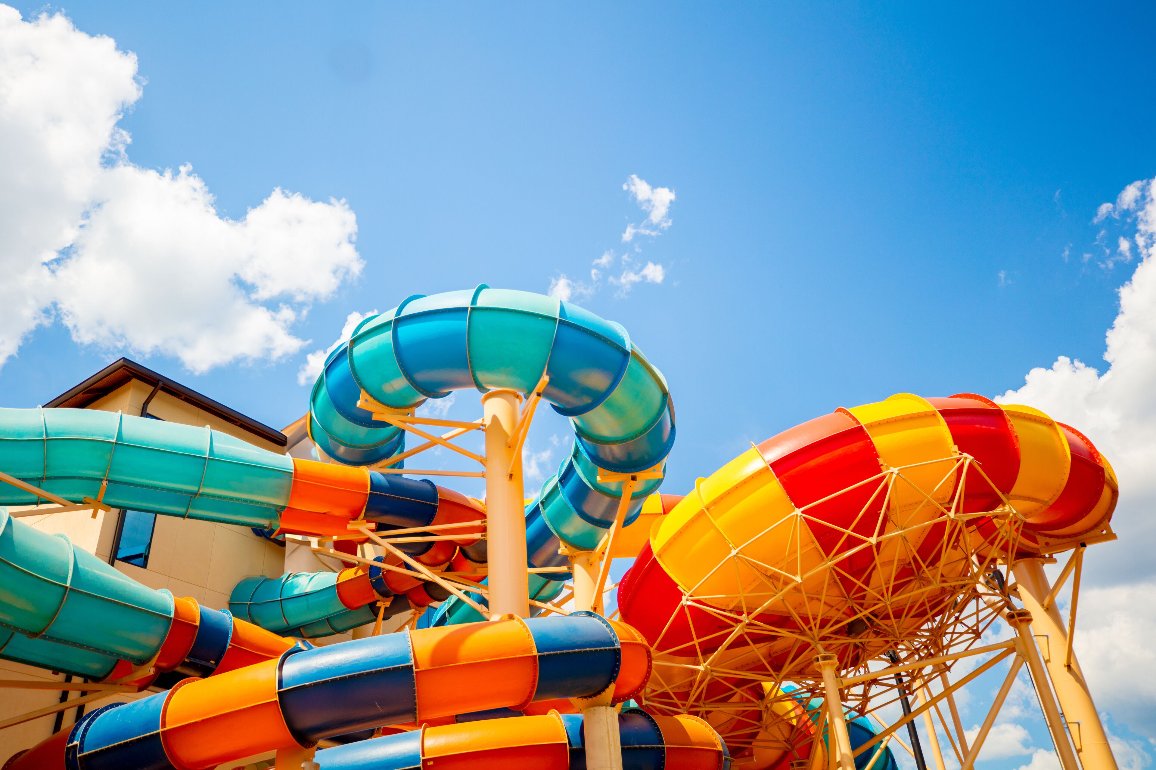 A water park with multiple water slides and a building in the background.