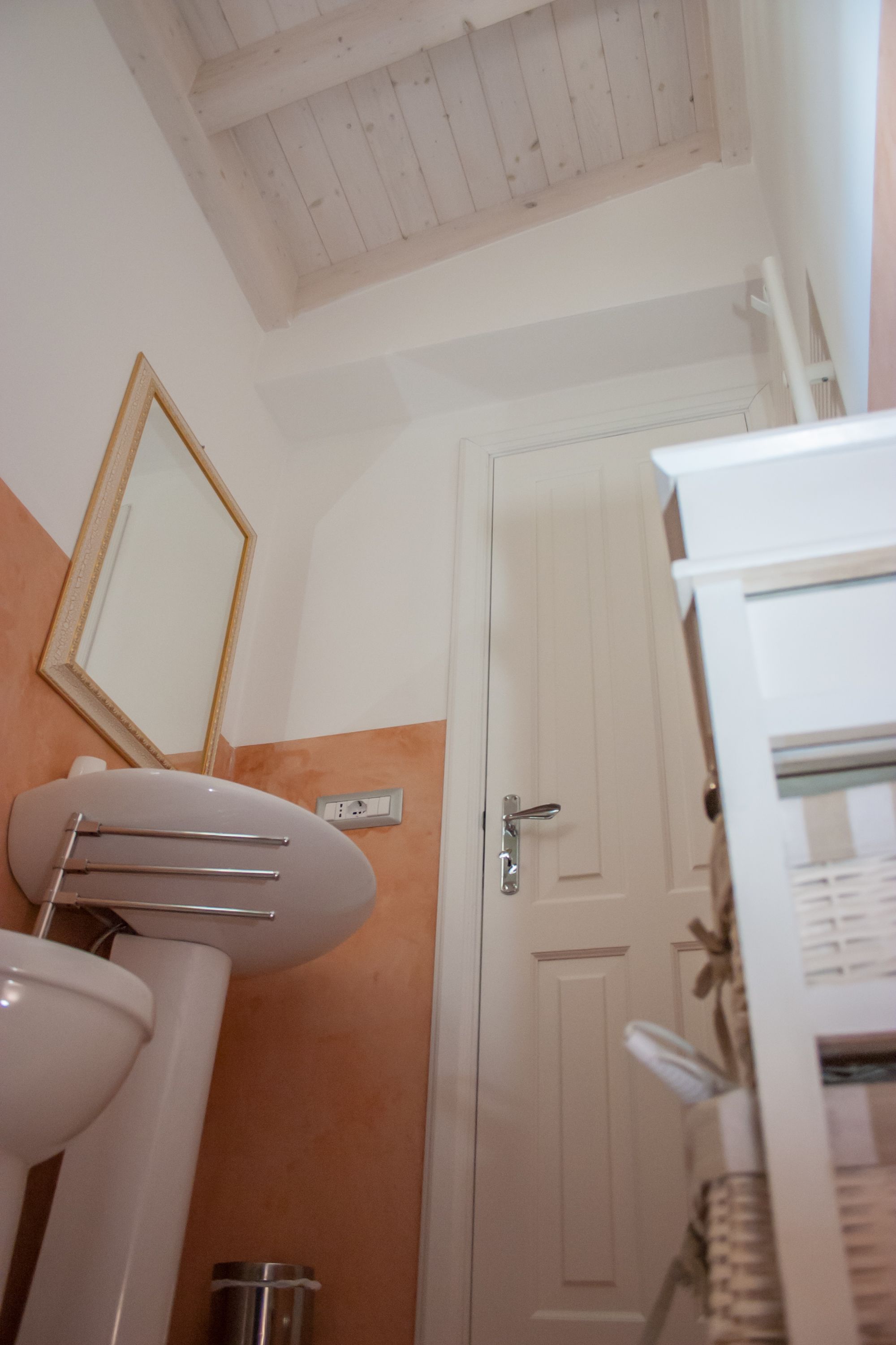 A bathroom with a white sink, a mirror, and a door.