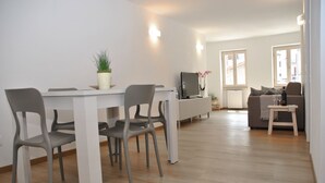 Un salon moderne comprenant un coin repas, un canapé et un téléviseur.