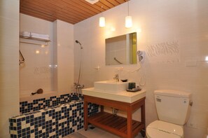 A bathroom with a tiled shower, a sink with a mirror, and a toilet. - Cheng-Ping Hot Spring Inn (Taimali)