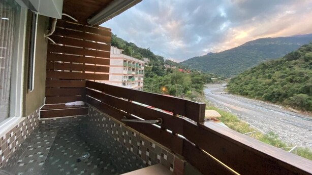 Un balcón con vistas a un río y montañas.