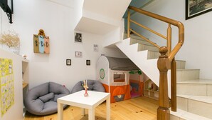 A modern interior with a staircase, a play area, and a white table. - Love 300 (Luodong)