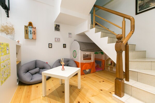 A modern interior with a staircase, a play area, and a white table. - Love 300 (Luodong)