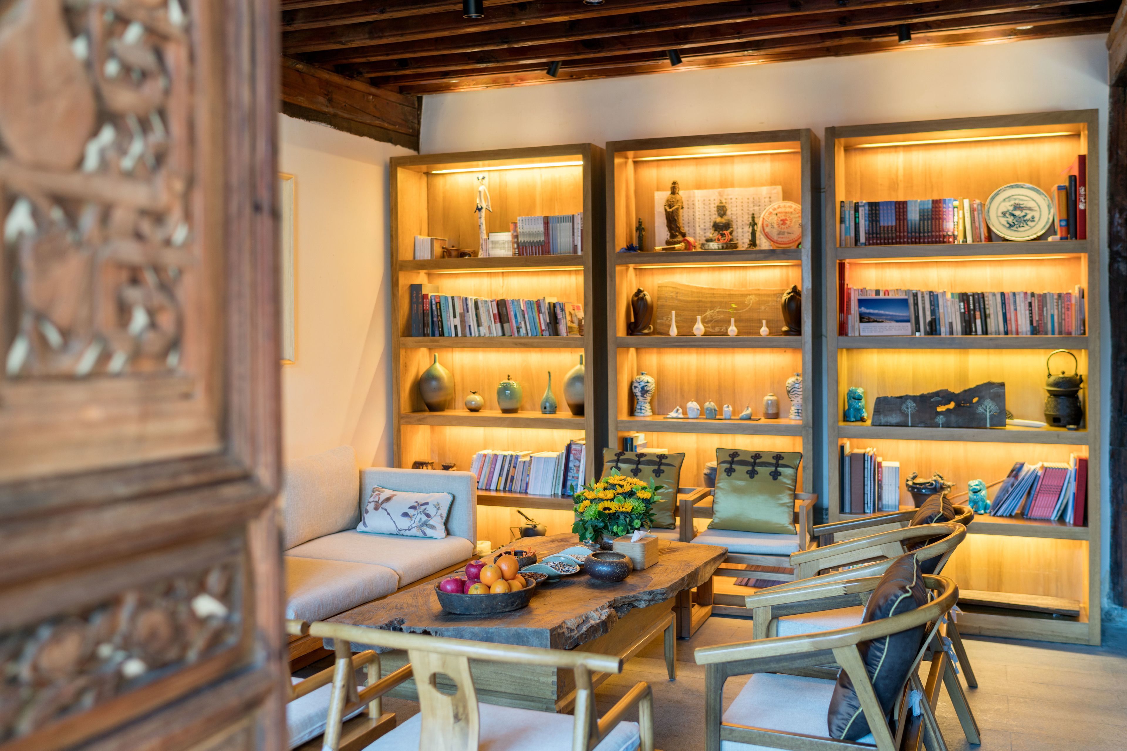 A cozy living room with a wooden coffee table, bookshelves, and a sofa.
