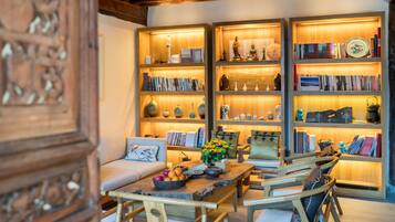 A cozy living room with a wooden coffee table, bookshelves, and a sofa.