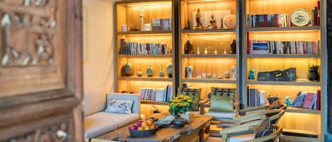 A cozy living room with a wooden coffee table, bookshelves, and a sofa.
