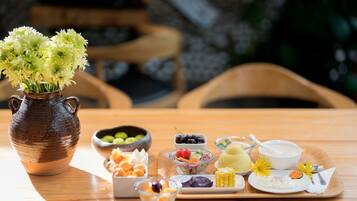 Una mesa de madera con diversos alimentos y un jarrón de flores.