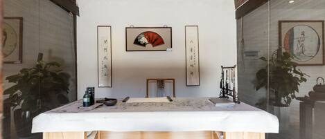 Una habitación japonesa tradicional con suelo de tatami, una mesa de madera baja y caligrafía en las paredes.