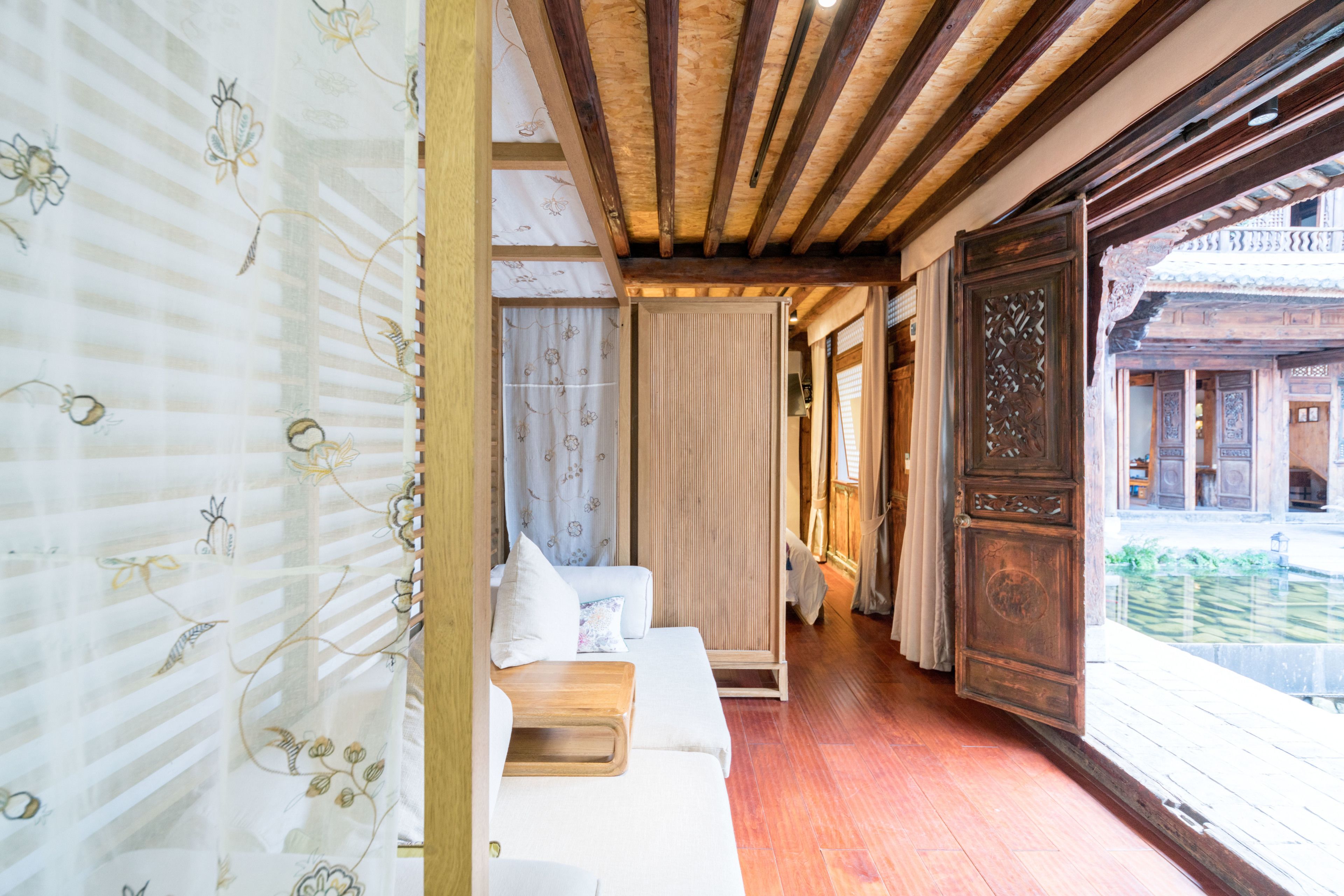 A traditional Japanese-style room with tatami flooring, a low wooden ceiling, and sliding doors.