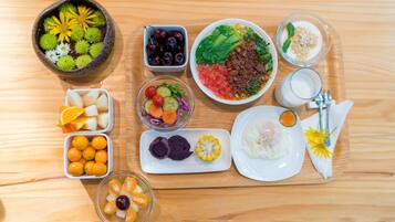 A wooden table with various food items and a glass of milk.