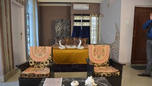 A living room with a sofa set, a coffee table, and a decorative swan centerpiece. - Hotel Siddarth Palace (Mangaldai)