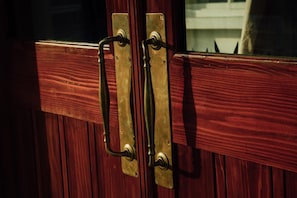 A wooden door with brass handles and a latch. - Orrs (Chatan)