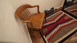 A wooden chair and table in a corner with a patterned rug. - Orrs (Chatan)