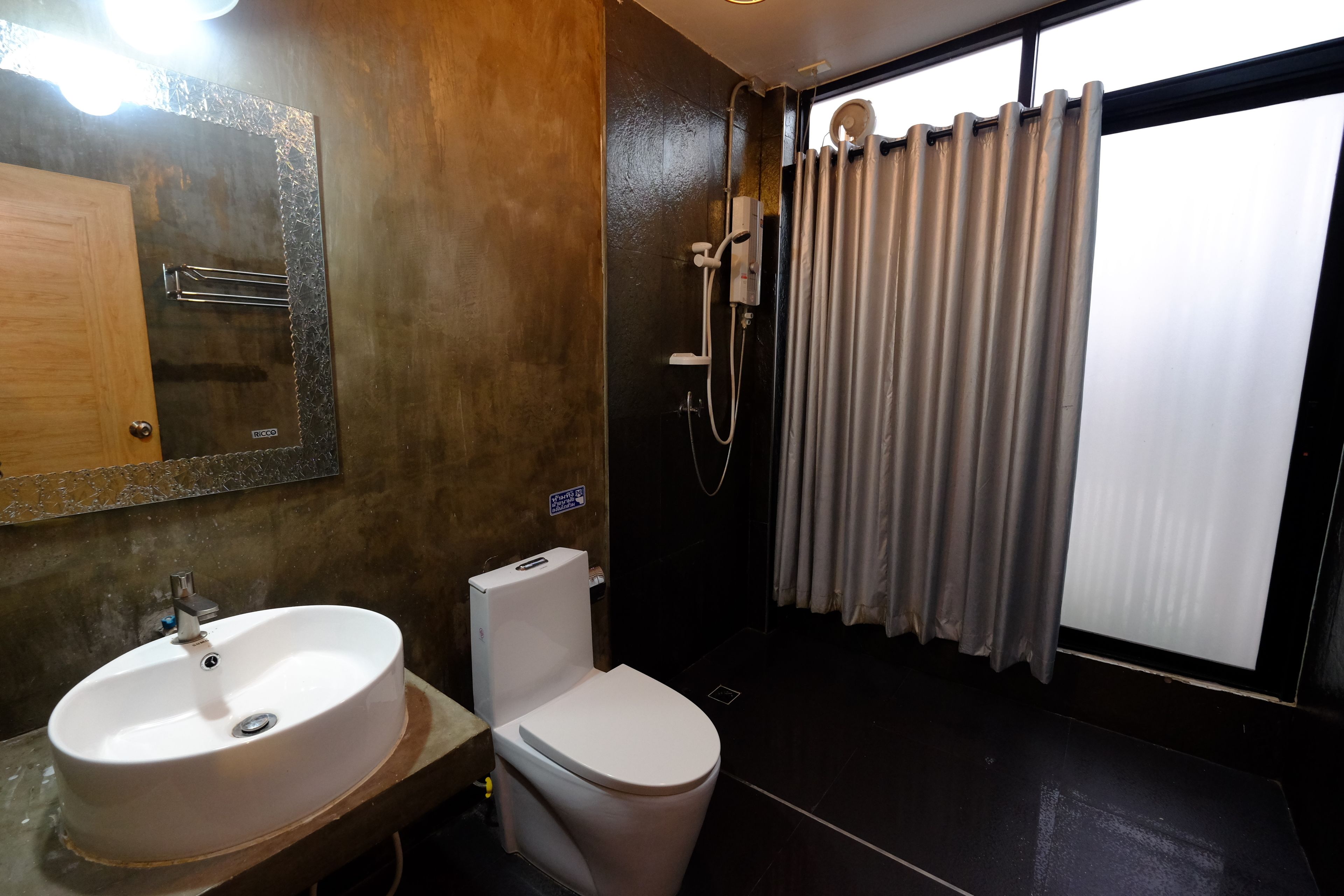 Une salle de bain équipée d’un lavabo, de toilettes et d’une douche.