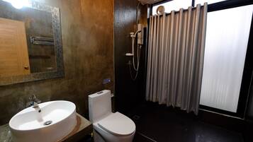 Une salle de bain équipée d’un lavabo, de toilettes et d’une douche.