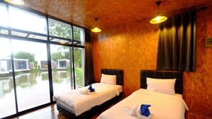 Une chambre d’hôtel avec deux lits, de grandes fenêtres et une vue sur un plan d’eau.