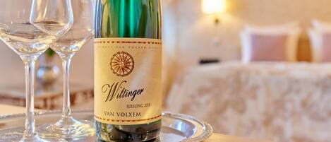 En flaske Riesling 2018 vin på et fad med to tomme vinglas.