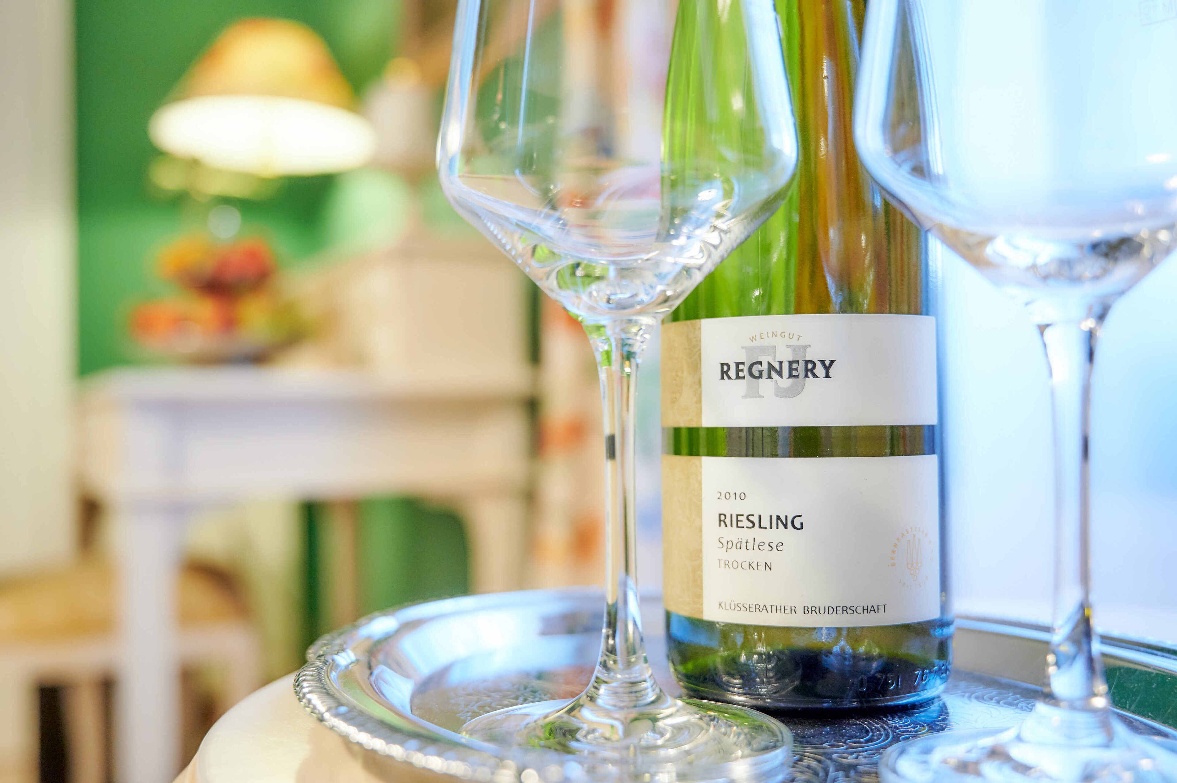 A bottle of Riesling wine with a label, placed on a tray with two wine glasses.