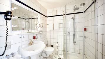 A modern bathroom with a sink, toilet, and glass-enclosed shower.