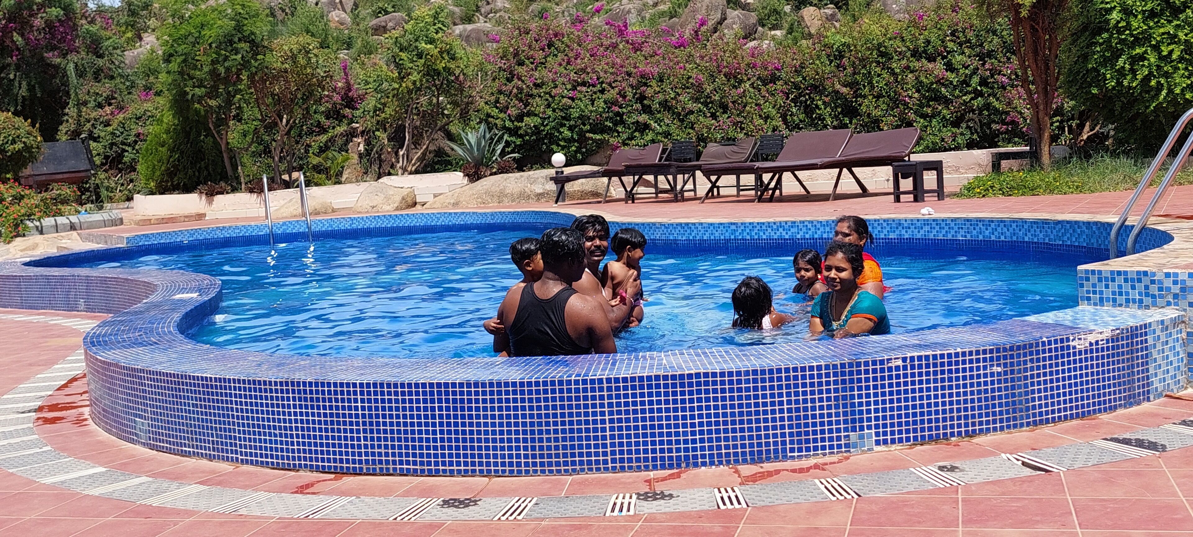 Outdoor pool, pool loungers, lifeguards on site