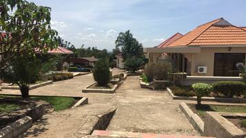 A residential area with houses, a paved driveway, and landscaped gardens.
