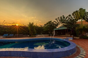 Una piscina al aire libre, tumbonas, socorrista en las instalaciones