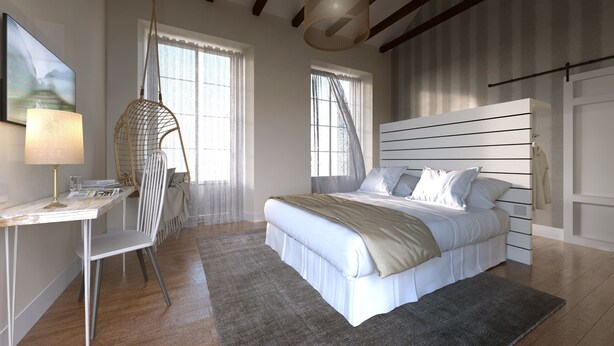 A bedroom with a bed, bedside table, chair, and a hanging light fixture. - Madeinterranea Suites (Málaga)