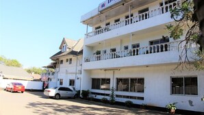 A multi-story building with balconies and a sign that reads "D-Lux Hotel". - Dlux Hotel (Nakuru)