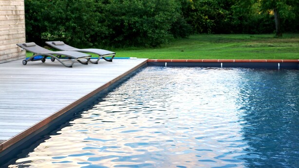 A swimming pool with a wooden deck and lounge chairs. - La Garoffe (Pibrac)