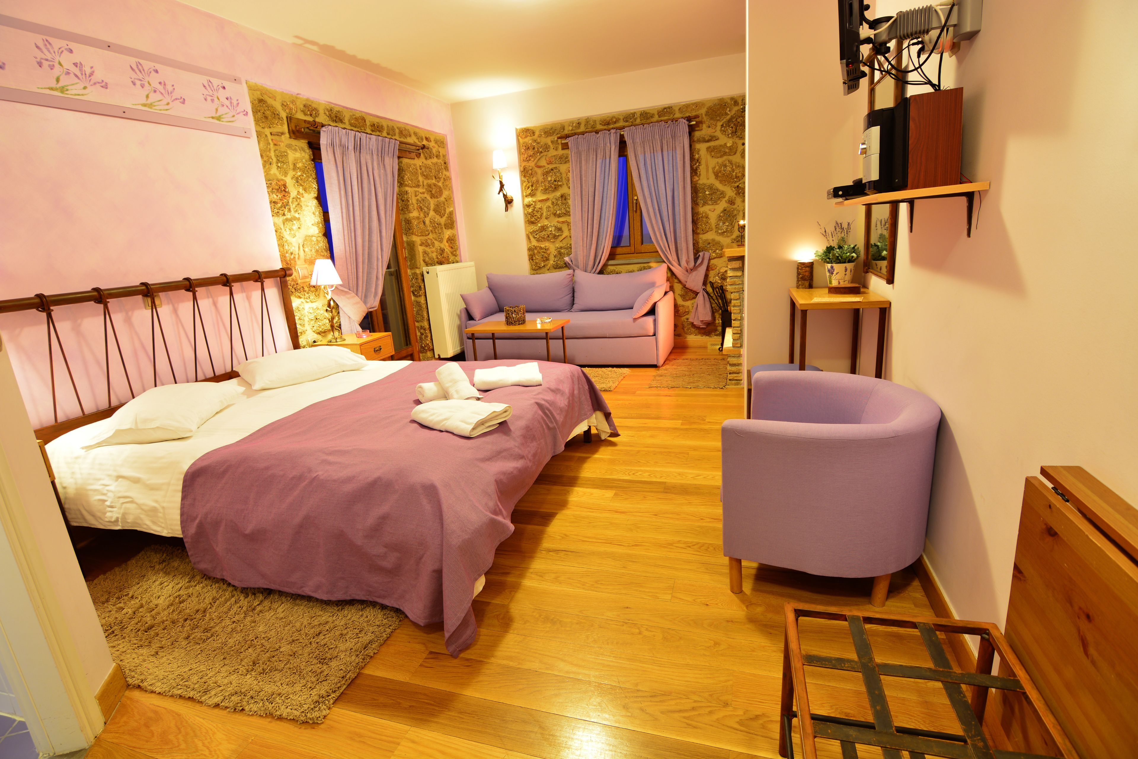 Un dormitorio con cama, sofá, sillón y una mesita.