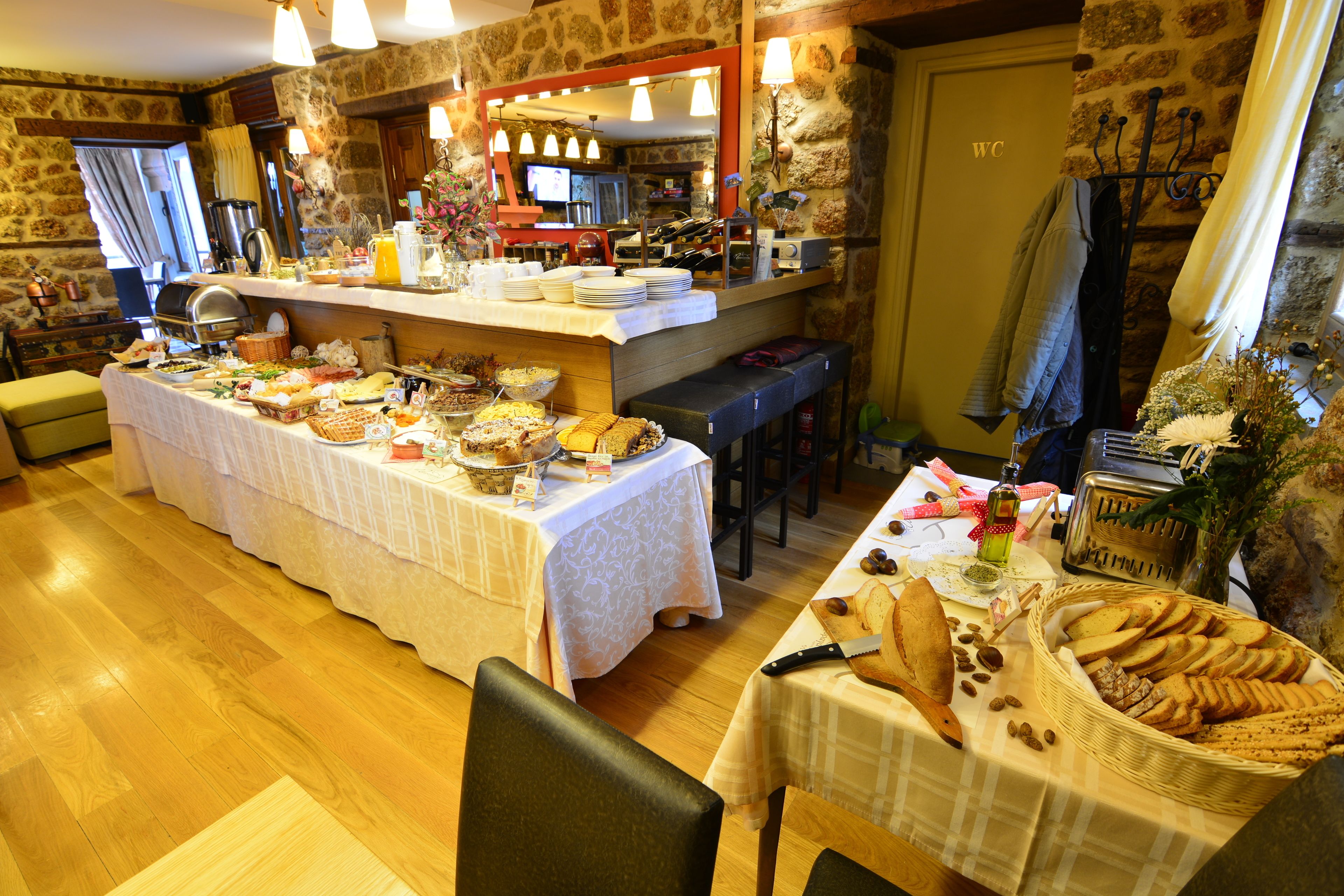 Un bufé de desayuno con diversos alimentos, una estación de café y una bodega de vinos.