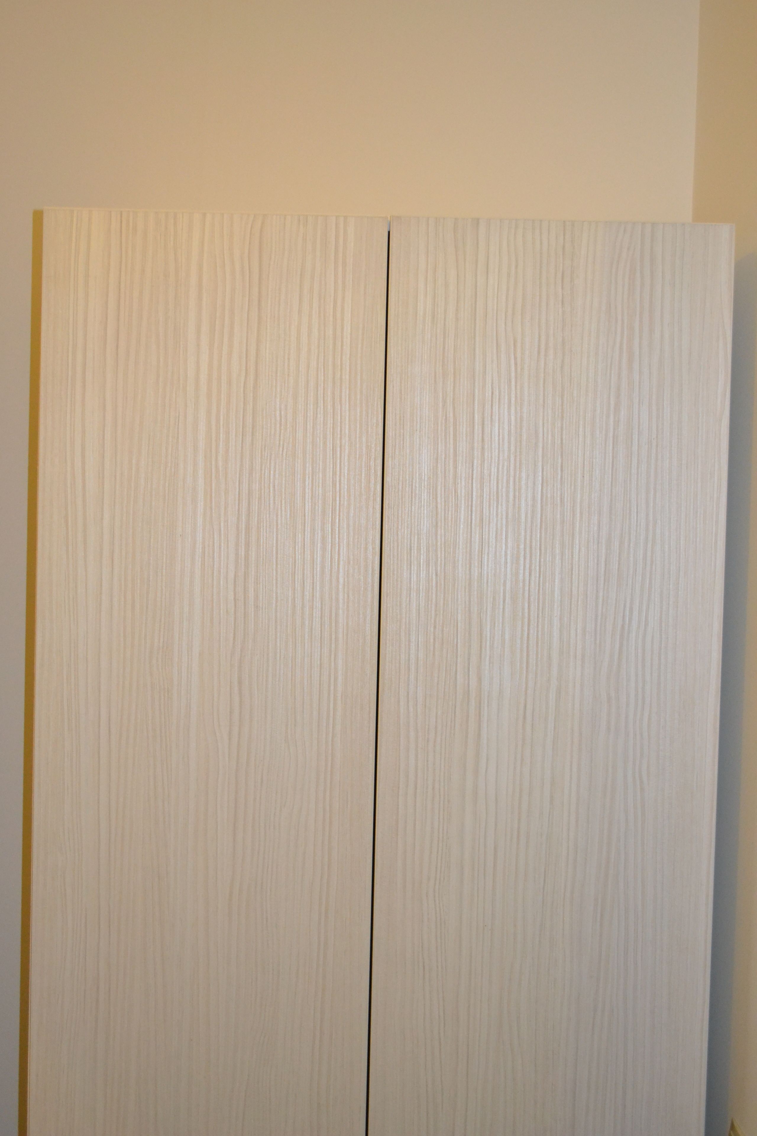 Ein Zimmer mit großem Kleiderschrank und Spiegel.