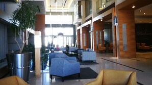 A spacious lobby with high ceilings, modern lighting, and comfortable seating areas. - Island Letting-Crystal towers (Cape Town)