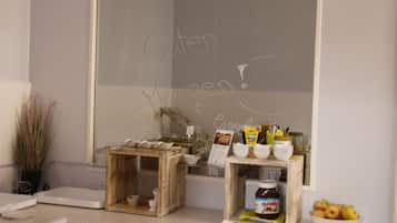 Una preparación para el desayuno con una pizarra que muestra 'Guten Morgen!' y una encimera de madera con productos para el desayuno.