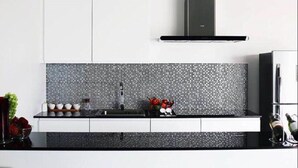 A modern kitchen with a black countertop, white cabinets, and a black backsplash. - L.A. Pool Villa Huahin (Hua Hin)