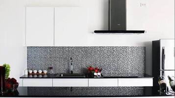 Standaard kamer | Privékeuken | Een koelkast met diepvriezer, een microgolfoven, een kookplaat