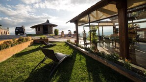 Un espace extérieur aménagé avec soin, comprenant une terrasse, un petit abri et une vue sur le paysage environnant.