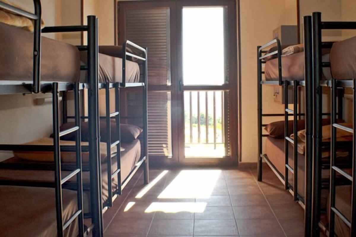 Un dormitorio con literas, una puerta corredera y vistas al exterior.