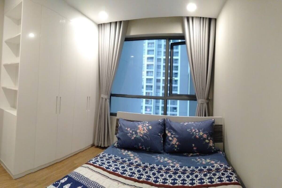Une chambre à coucher comprenant un lit, une fenêtre et une porte donnant sur un coin repas.