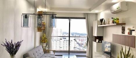 Appartamento Deluxe, 2 camere da letto, accesso alla piscina, vista città | Soggiorno | TV a schermo piatto 55 pollici con canali via cavo, TV, lettore DVD